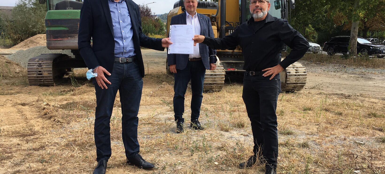 Ralph Gumb mit Kreisbeigeordnetem Krug und Bürgermeister Richter vor zwei Baggern
