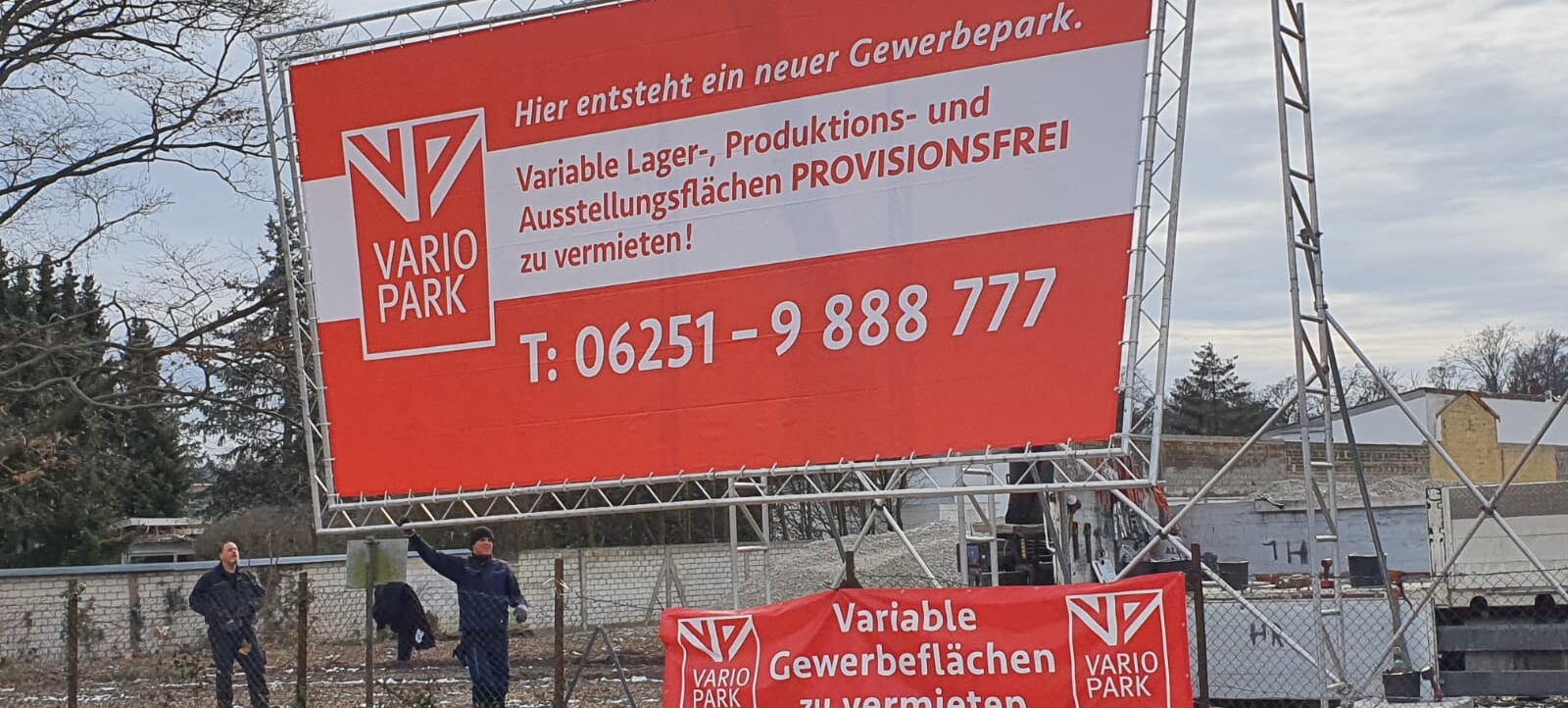 Kran beim Aufbau eines Riesenwerbeschild mit VarioPark-Werbung